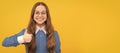 Happy nerdy-looking girl child give thumbs up satisfaction hand gesture yellow background, childhood. Child face