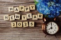 Happy New Year 2025 with alarm clock on wooden background