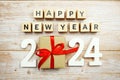 Happy New Year 2024 alphabet letters and gift box presents on wooden background Royalty Free Stock Photo