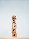 Target icon on wood sphere on top of 2024 year numbers on wooden cube blocks stack on white background. Royalty Free Stock Photo