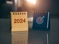 Happy new year 2024 banner background. 2024 number year with target icon on brown and blue small desk calendar cover.