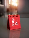 2024 numbers year with target icon on red small desk calendar cover standing on table with copy space.