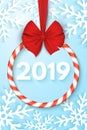 Happy New Year 2019 banner. Christmas sweet spiral lollipop with red ribbon and bow. Cut out of paper snowflakes on a blue backgro Royalty Free Stock Photo
