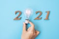 2021 Happy New year with Businessman holding lightbulb with and wooden number. New Start, Idea, Creative, Innovation, Resolution,