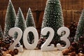 Happy New year calendar 2023 concept decoration with Christmas tree and pine cones on wooden background Royalty Free Stock Photo