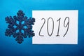 2019 Happy New Year card with text and glitter snowflake on blue background