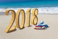 Happy new year card. Two New Year`s caps of Santa Claus on beach and inscription 2018 in the sand Royalty Free Stock Photo