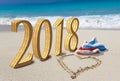 Happy new year card. Two New Year`s caps of Santa Claus on beach and on sand heart is drawn and inscription 2018 Royalty Free Stock Photo