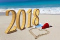 Happy new year card. Two New Year`s caps of Santa Claus on beach and on sand heart is drawn and inscription 2018 Royalty Free Stock Photo