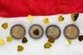 Happy new year celebration background. Coins make 2022 on a red Santa Claus hat and golden confetti