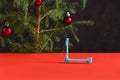 Happy New Year 2020. Christmas composition. Mini scooter on a red table with a Christmas tree and