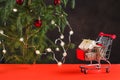 Happy New Year 2020. Christmas composition. Mini trolley with gift boxes near a Christmas tree with