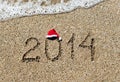 Happy new year 2014 with christmas hat on sandy beach - holiday Royalty Free Stock Photo