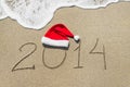 Happy new year 2014 with christmas hat on sandy beach Royalty Free Stock Photo