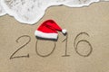 Happy new year 2016 with christmas hat on sandy beach Royalty Free Stock Photo