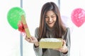 Happy New Year, Christmas and Holiday Seasonal Concept. Portrait of young asian woman holding and opening a beautiful gift box Royalty Free Stock Photo