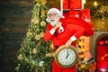 Happy new year. Christmas time. Its almost twelve clock. Santa make funny face and holding clock showing five minutes to Royalty Free Stock Photo