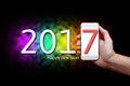 2017 Happy New Year Concept, Body part, Hand holding mobile phone and number seven on screen. Royalty Free Stock Photo