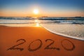 Happy New Year 2020 concept, lettering on the beach. Sea sunrise Royalty Free Stock Photo