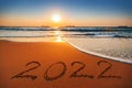 Happy New Year 2022 concept, lettering on the beach sand. Sea sunrise Royalty Free Stock Photo