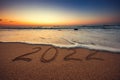Happy New Year 2022 concept, lettering on the beach. Sea sunrise Royalty Free Stock Photo