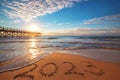 Happy New Year 2023 sunrise beach concept, lettering on the sea sand. Written text on ocean seashore at sunset. Royalty Free Stock Photo