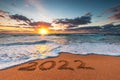 Happy New Year 2022 concept, lettering on the beach. Written text on the sea sand at sunrise Royalty Free Stock Photo