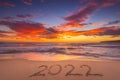 Happy New Year 2022 concept, lettering on the beach. Written text on the sand on sunrise Royalty Free Stock Photo