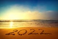 Happy New Year 2022 concept, lettering on the beach. Written text on the sea beach at sunrise Royalty Free Stock Photo
