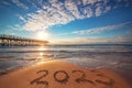 Happy New Year 2023 concept, lettering on the beach. Written text on the sea beach at sunrise