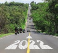 2022 Happy New Year concept with motorcyclists traveler driving across the slope country asphalt road uphill