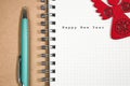 Happy New Year concept, Notebook and green pen with wooden red a Royalty Free Stock Photo