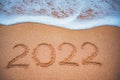 Happy New Year 2022 concept on the sea beach sand. Ocean sunrise Royalty Free Stock Photo