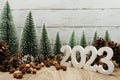 Happy New year 2023 decoration with Christmas tree and pine cones on wooden background Royalty Free Stock Photo