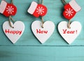 Happy New Year.Decorative white wooden Christmas hearts and red mittens on blue wooden background.Winter holidays concept. Royalty Free Stock Photo