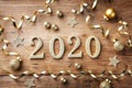 Happy New Year festive background with golden numbers 2020 and Christmas decorations on vintage wooden table top view Royalty Free Stock Photo