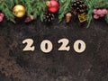 Happy New Year festive background with wooden numbers 2020 and Christmas decorations on dark stone surface. Top view Royalty Free Stock Photo