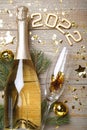 Happy New Year 2022! Flat lay composition with bottle of sparkling wine on wooden table Royalty Free Stock Photo