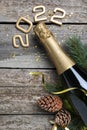 Happy New Year 2022! Flat lay composition with bottle of sparkling wine on wooden table Royalty Free Stock Photo