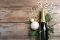 Happy New Year 2022! Flat lay composition with bottle of sparkling wine on wooden table, space for text Royalty Free Stock Photo