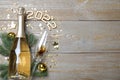 Happy New Year 2022! Flat lay composition with bottle of sparkling wine on wooden table, space for text Royalty Free Stock Photo