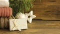 happy new year, gift in white box on wooden background next to christmas toys and spruce branch
