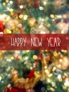 Happy New Year greeting card on blurred background with decorated natural green fir tree with red golden silver glittering balls Royalty Free Stock Photo