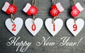 Happy New Year greeting card.Decorative white wooden Christmas hearts and red mittens with 2019 numbers on old wooden background. Royalty Free Stock Photo