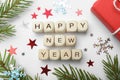 Happy New Year greeting card. Phrase made with cubes and festive decor on white background, flat lay