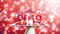 Happy New Year 2019, Hand holding digital tablet with red Bokeh fireworks background Royalty Free Stock Photo