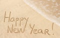 Happy New Year handwritten on sand Royalty Free Stock Photo