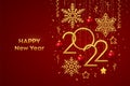 Happy New 2022 Year. Hanging Golden metallic numbers 2022 with shining snowflakes, 3D metallic stars, balls and confetti on red Royalty Free Stock Photo