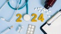 Happy new year 2024 for health care and medical concept.Golden wood numbers with Stethoscope,Syringe,Medical bottle and pills on