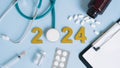 Happy new year 2024 for health care and medical concept.Golden wood numbers with Stethoscope,Syringe,Medical bottle and pills on